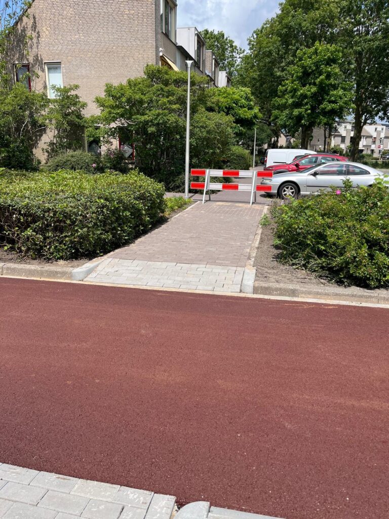 Opgeleverd rood fietspad met trottoirinrit en aansluitende bestrating