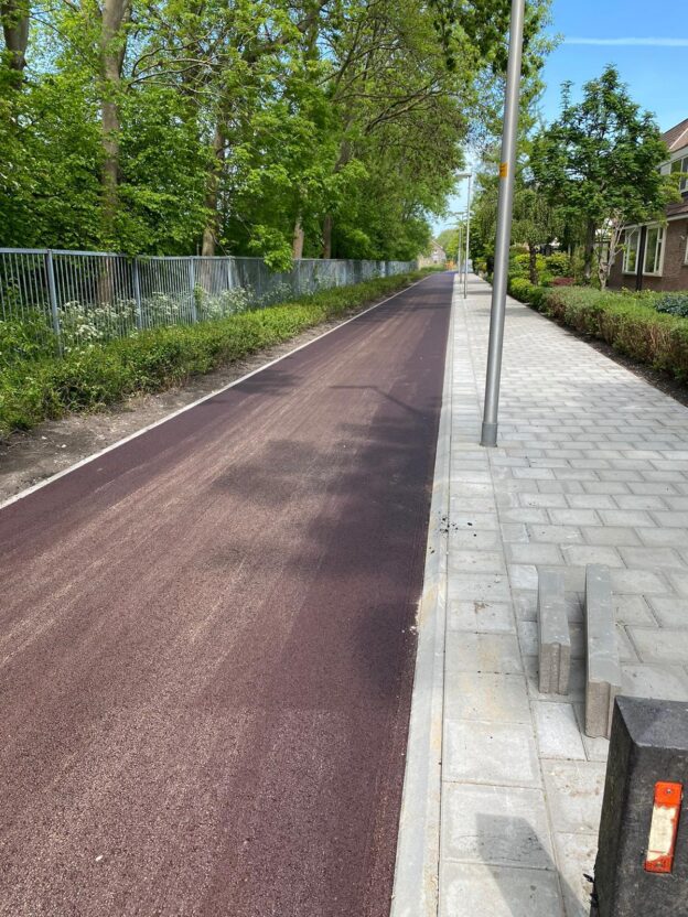 Nieuw rood fietspad langs een woonstraat