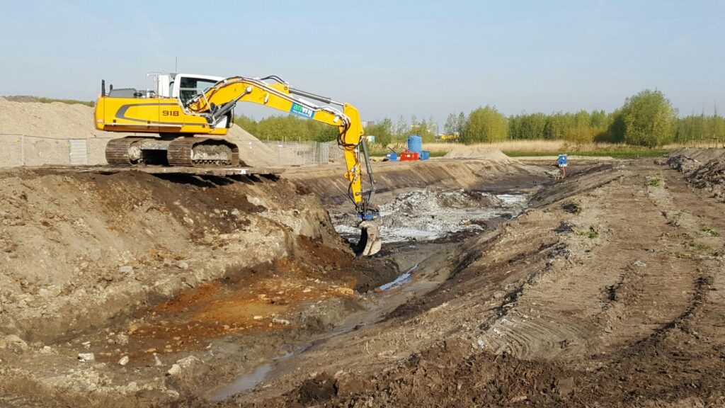 Kraan ontgraaft verontreinigde grond in een ontgraving
